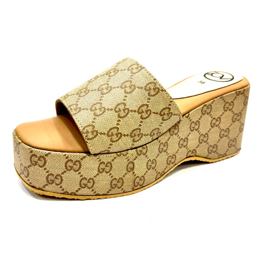 Beige wedge sandal with Gucci logo pattern on a white background