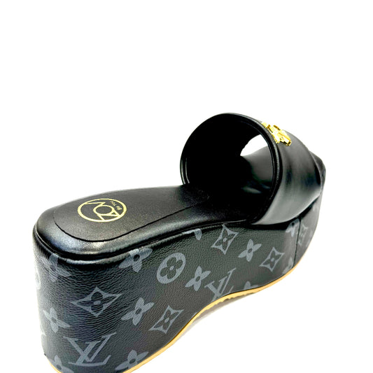 Black shoe with monogram pattern on a white background