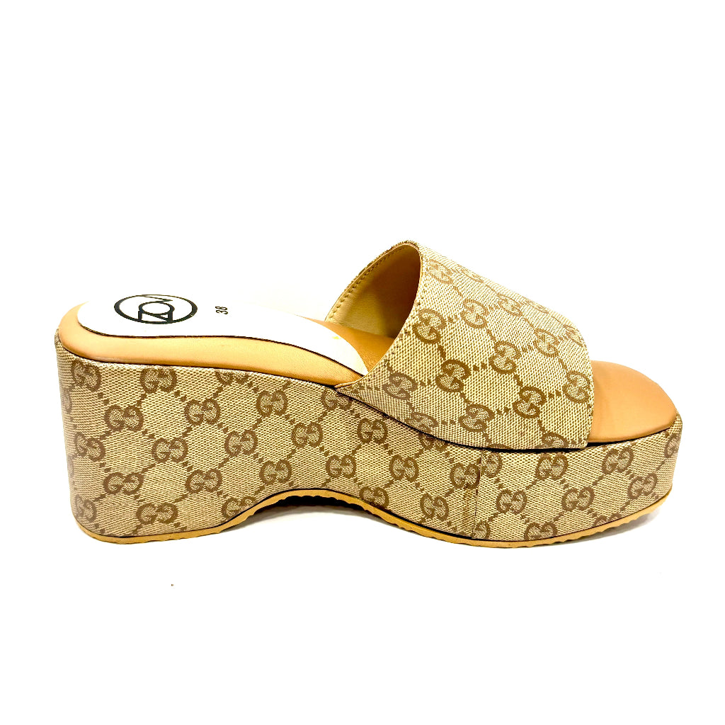 Beige wedge sandal with Gucci logo on a white background
