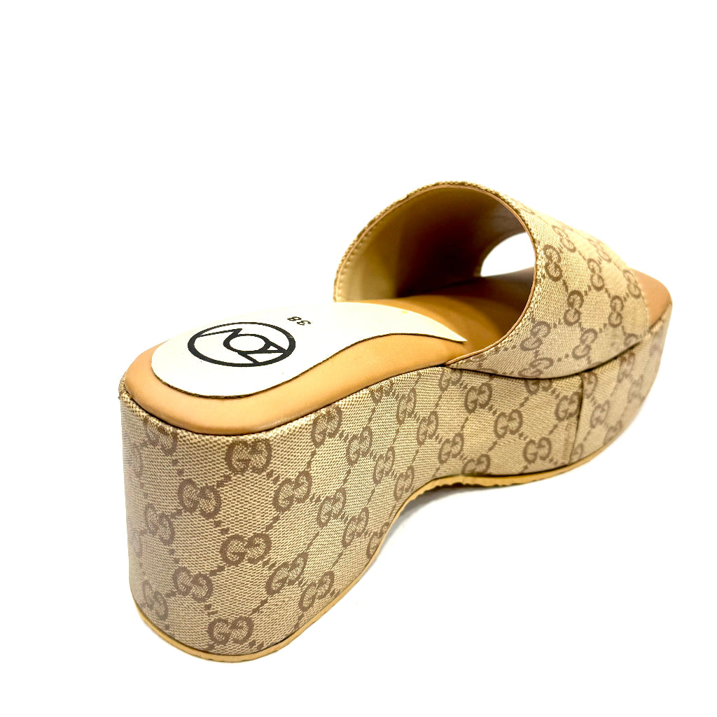 Beige wedge sandal with Gucci logo on a white background