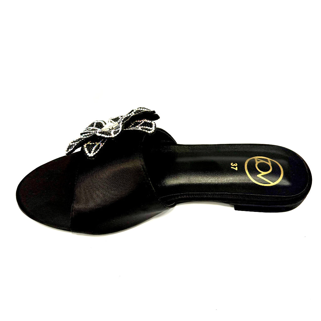 Black sandal with decorative element on a white background