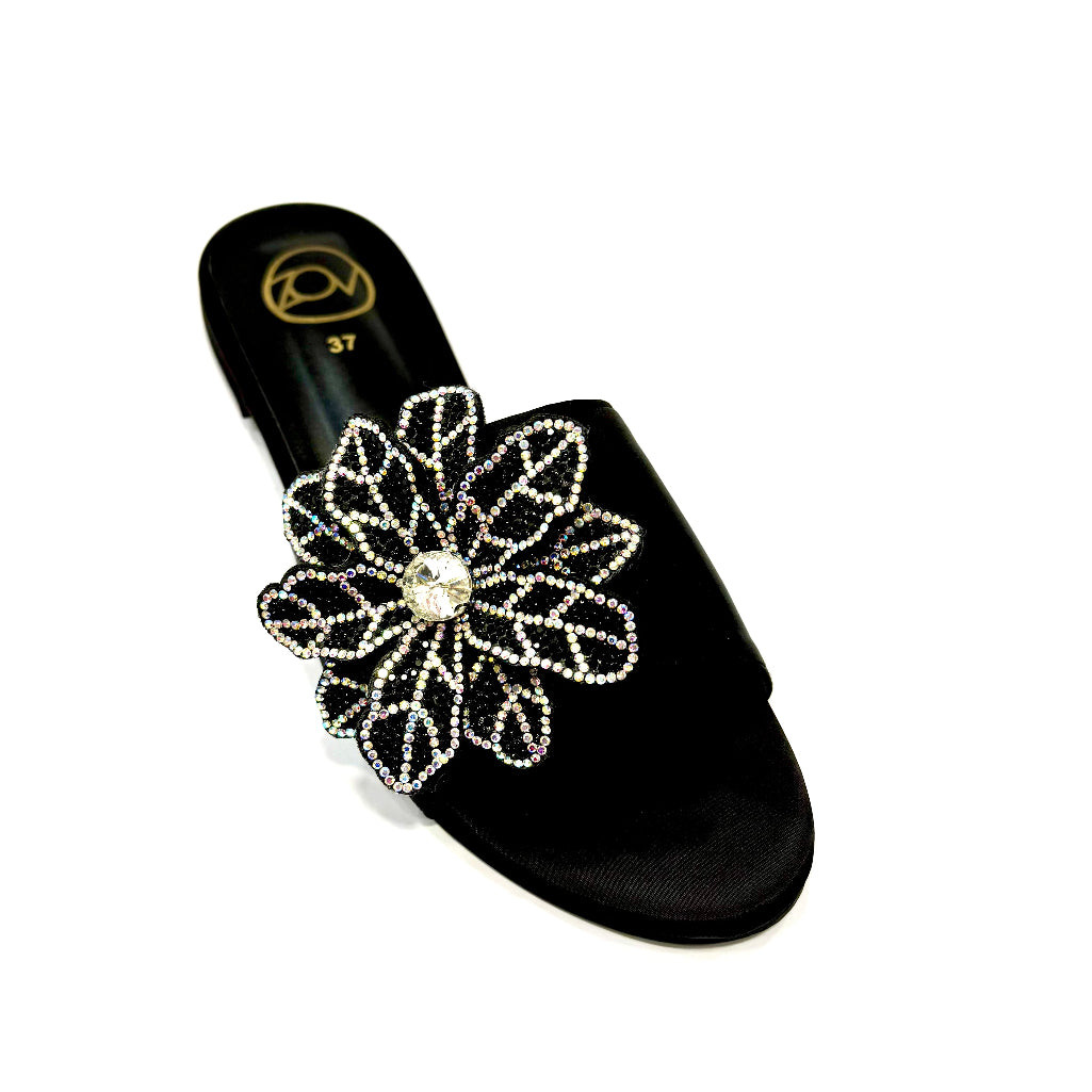 Black sandal with a decorative flower design on a white background