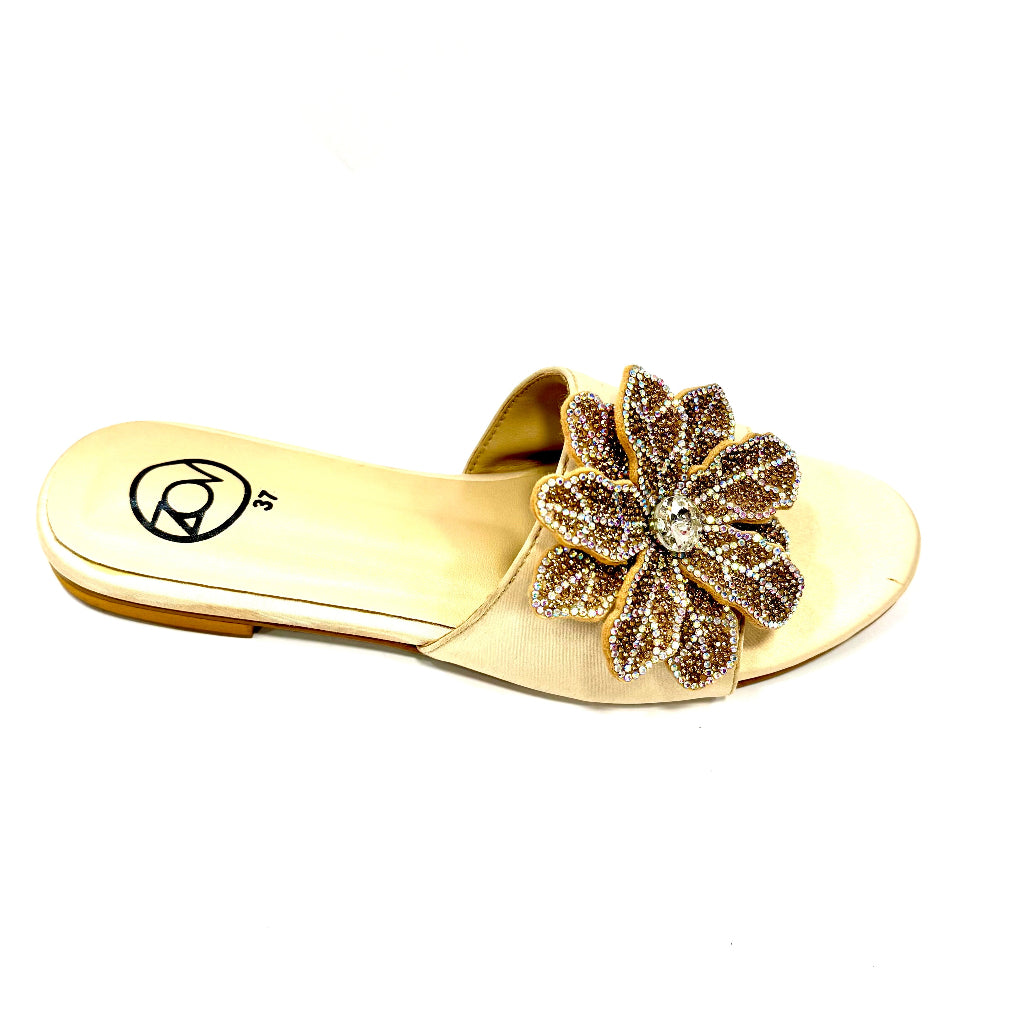 Gold sandal with a decorative flower on a white background