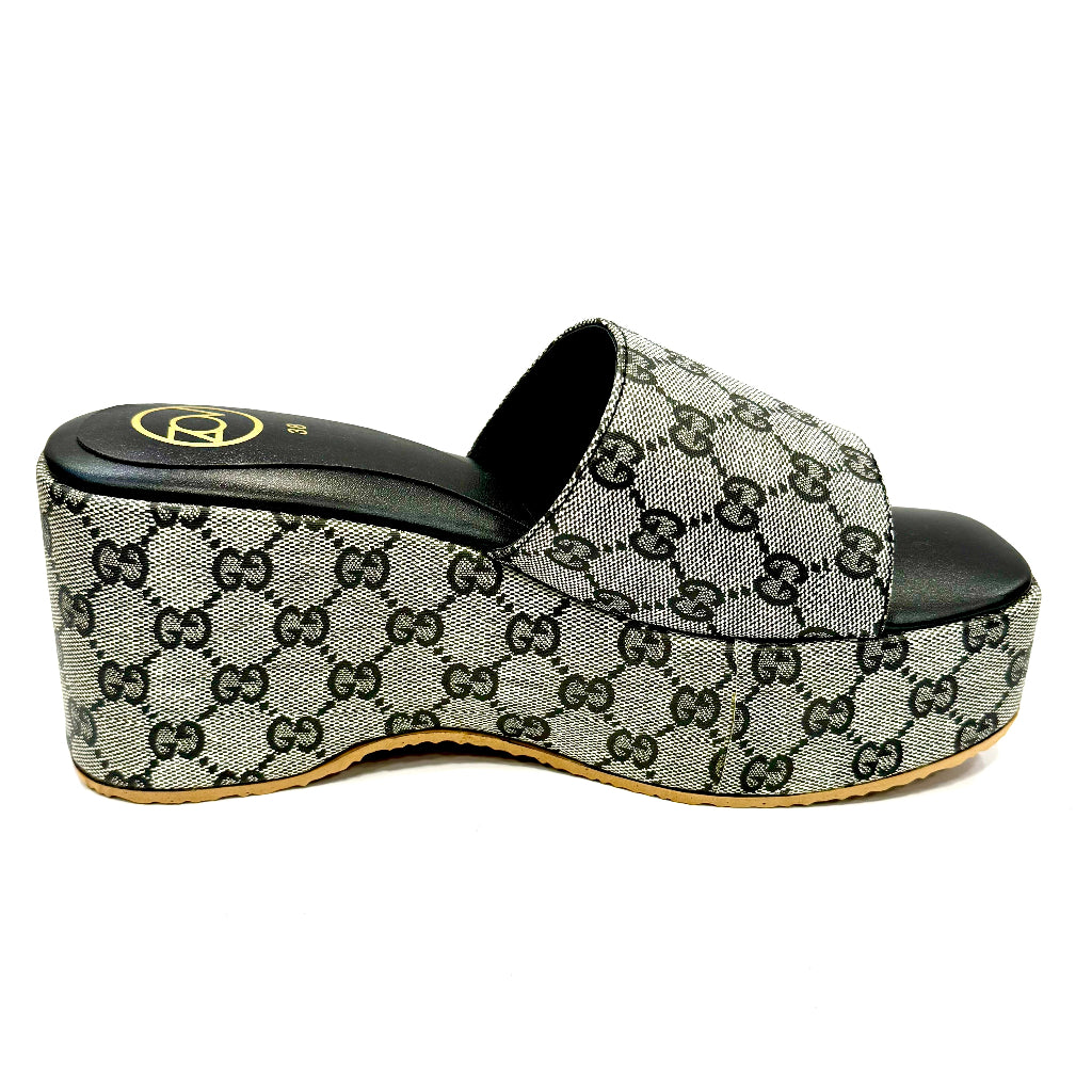 Gucci slide sandal with monogram pattern on a white background
