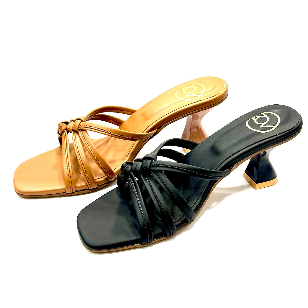 Pair of tan and black high-heeled sandals on a white background