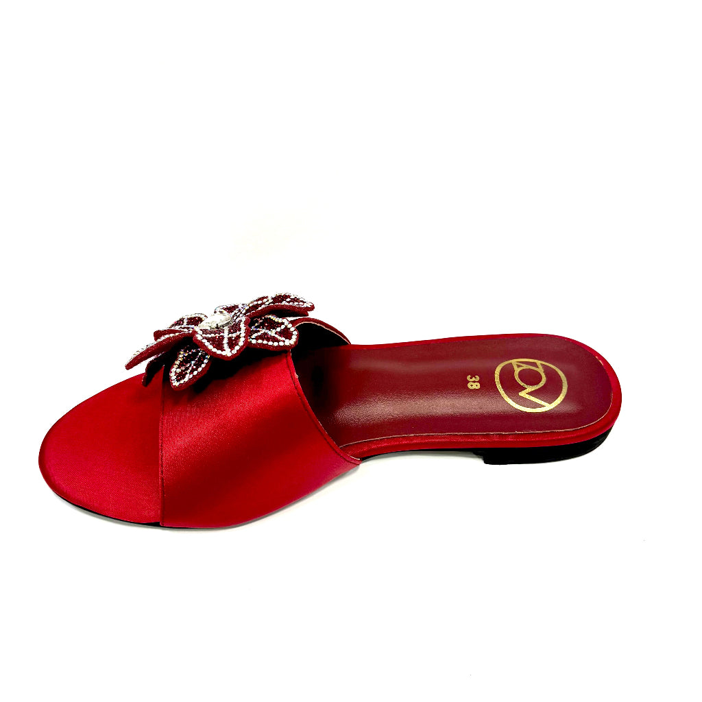 Red sandal with a decorative bow on a white background