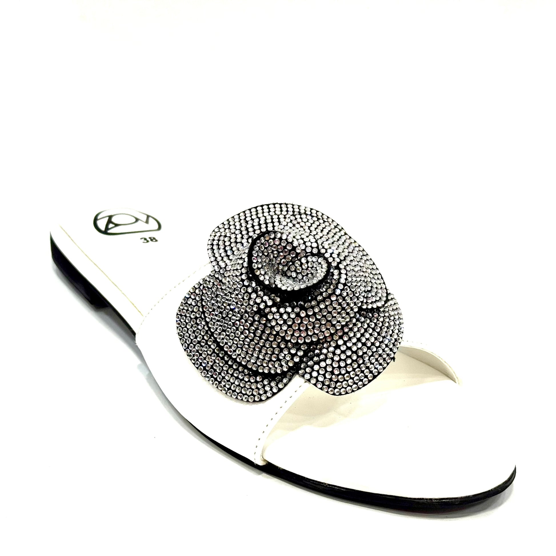 White sandal with a decorative black flower on a white background