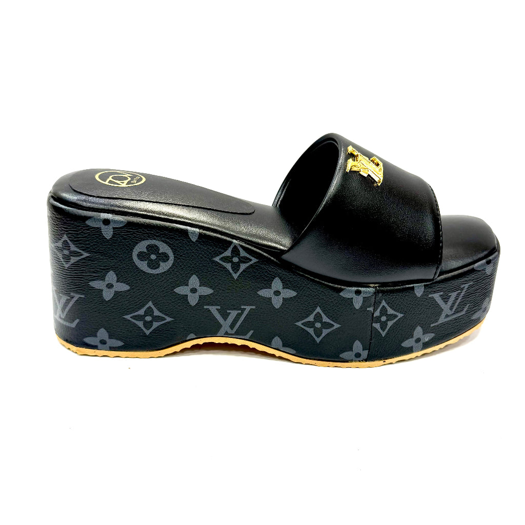Black wedge sandal with monogram pattern on a white background